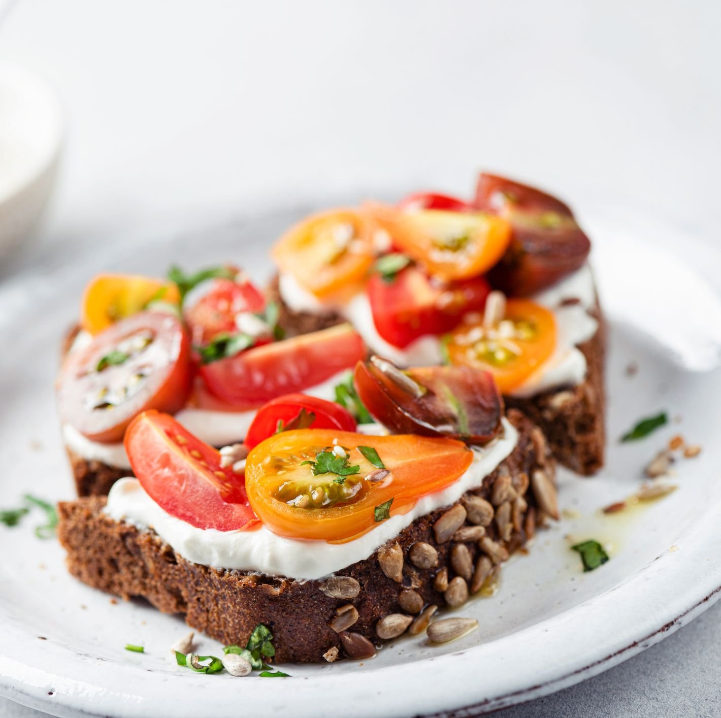 healthy rye bread toast with soft white cheese and tomatoes