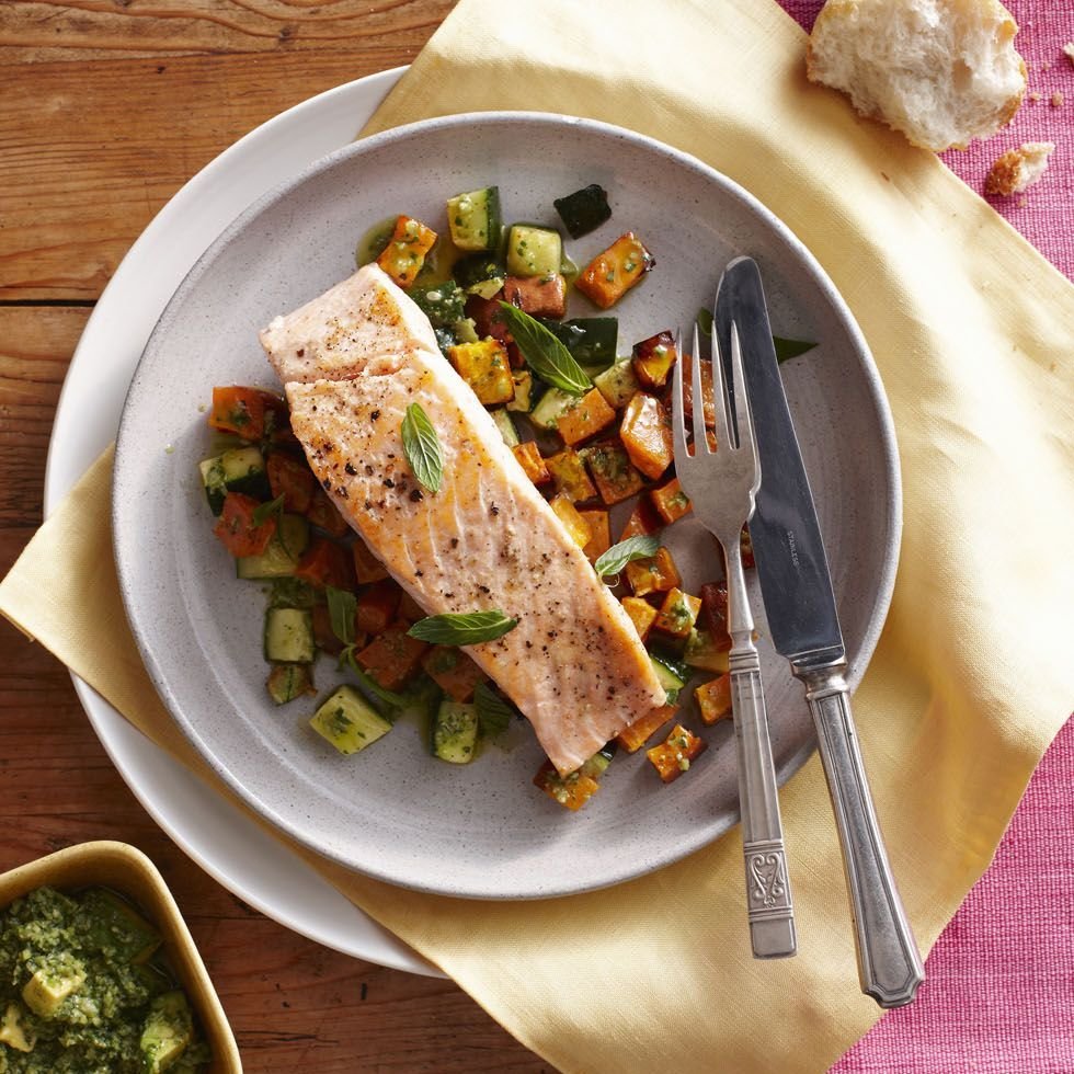 a grey plate with baked salmon on top of bed of vegetables, a good housekeeping pick for a healthy weight loss food
