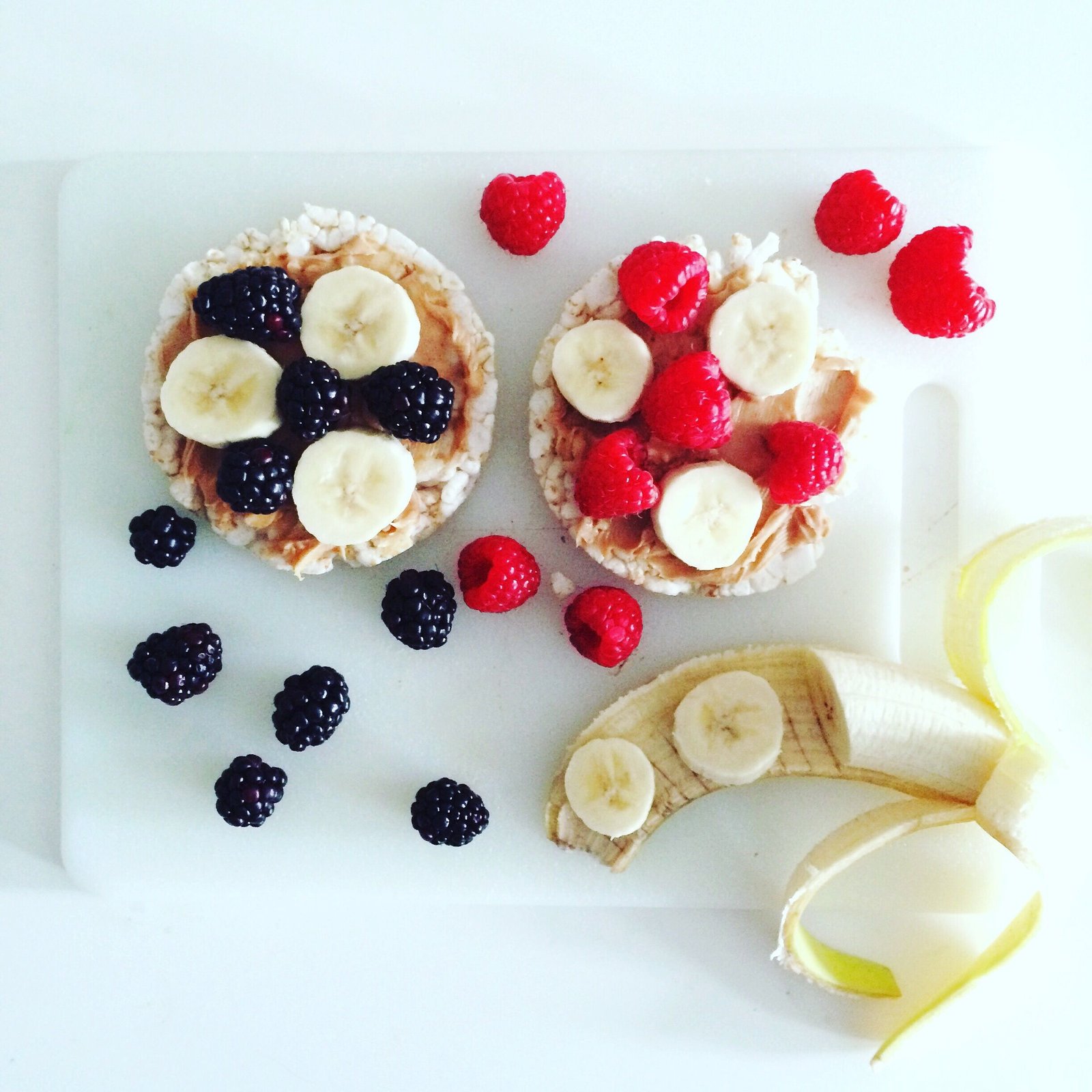 rice cake nut butter and berry sandwiches on a white plate